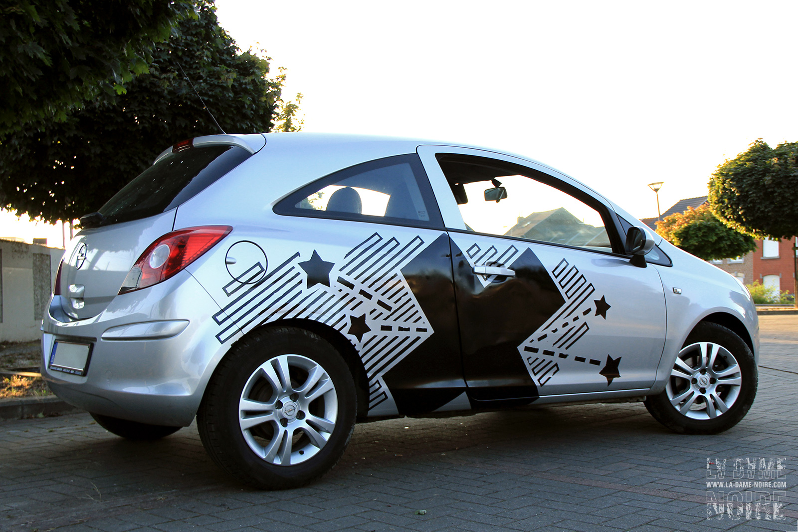 Right side of the Opel Corsa painted with a black cross and some black starts