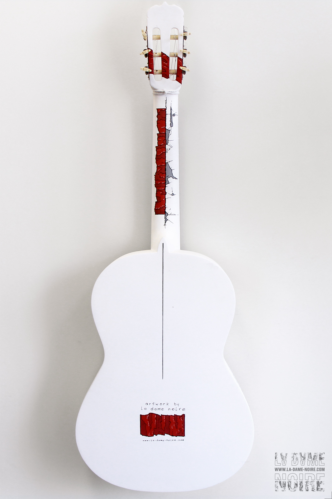 Back side side of an acoustic guitar painted in white and red