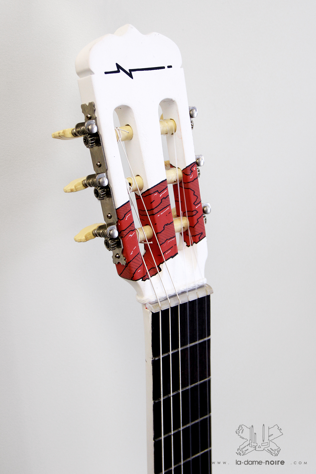 Détails de la tête de la guitare customisée en noir et blanc