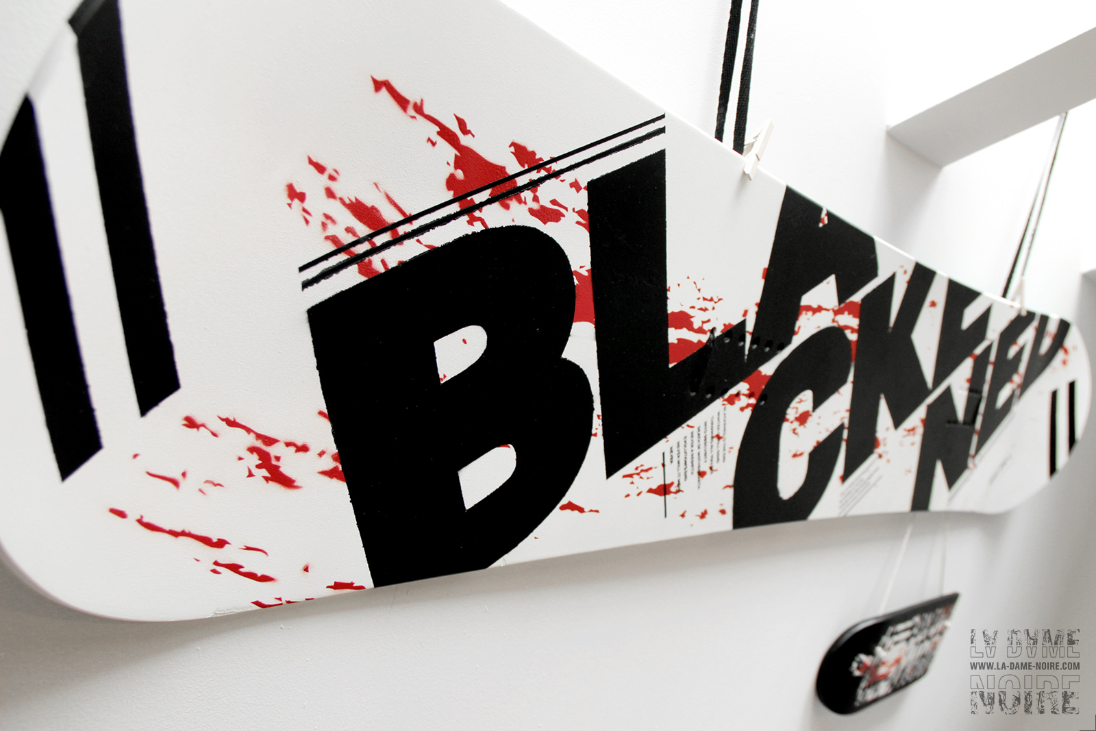Snowboard painted in black, white, red, and the word Blackened in big bold letters