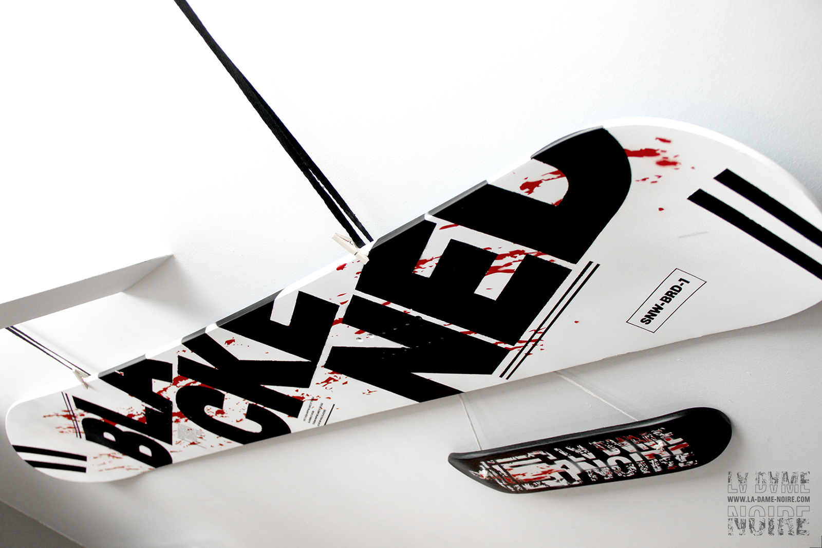 Détail du snowboard peint en noir et blanc avec le mot blackened