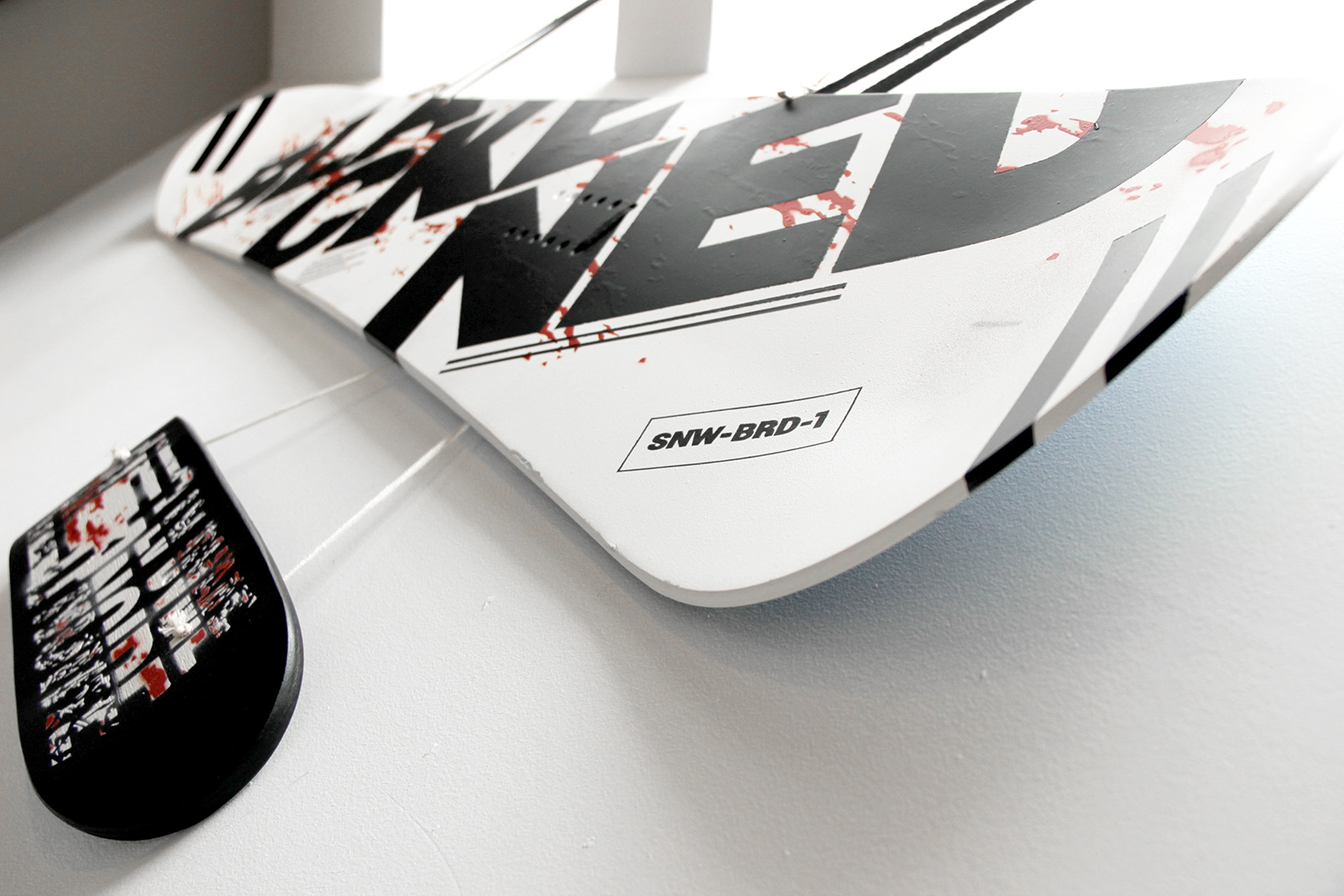 Dynamic picture of the snowboard painted in black, white, red, and the word Blackened in big bold letters