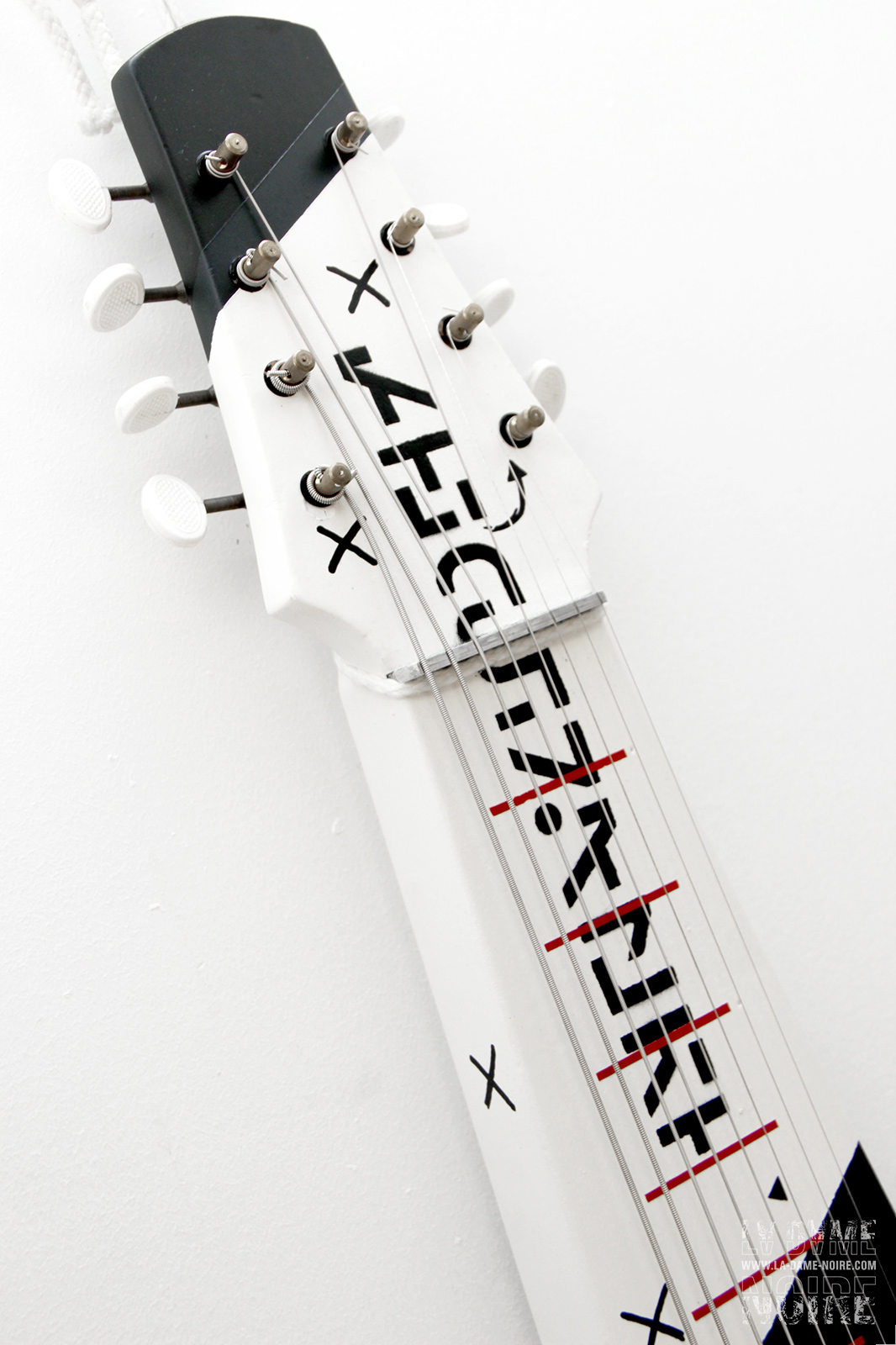 Head of the hawaian guitar painted in white, black and red stripes
